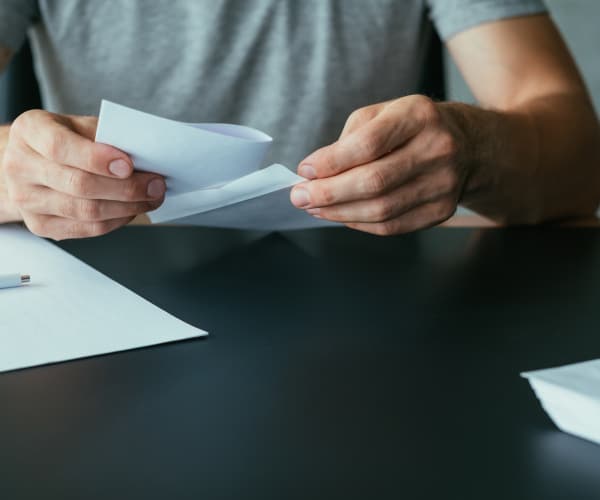 Close up view of a person holding an envelope with a cheque
